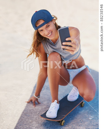 Summertime is selfie time. Shot of a young skater taking at selfie at the beach. Summertime is selfie time. Shot of a young skater taking at selfie at the beach. 88238546