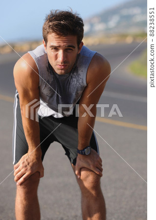 Catching his breath. Tired young runner leaning over to catch his breath. Catching his breath. Tired young runner leaning over to catch his breath. 88238551