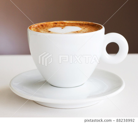 The only start to a morning. Shot of a freshly-made cappuccino on a white table. 88238992