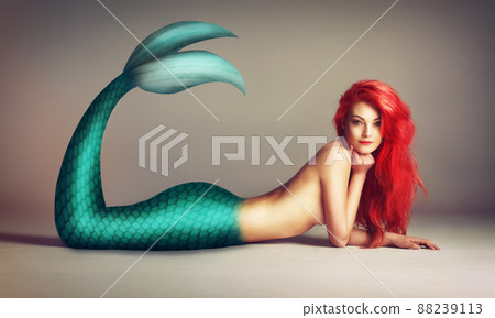 Shes a catch. Shot of a beautiful red-headed mermaid lying down. 88239113