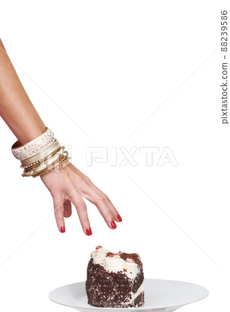 Reaching for her delicious prize. Cropped image of a womans hand reaching for a slice of cake. 88239586