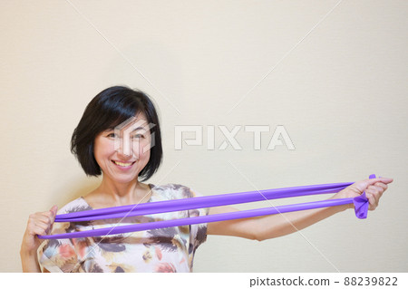 Middle-aged woman doing muscle training with a rubber band 88239822