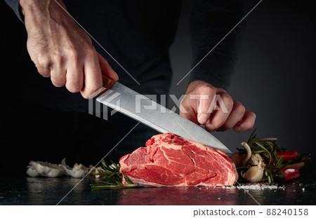 Chef cutting raw beef meat. Chef cutting raw beef meat. 88240158