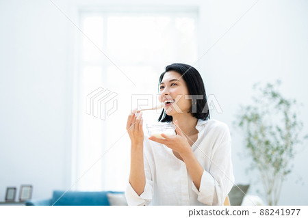 Woman eating yogurt 88241977