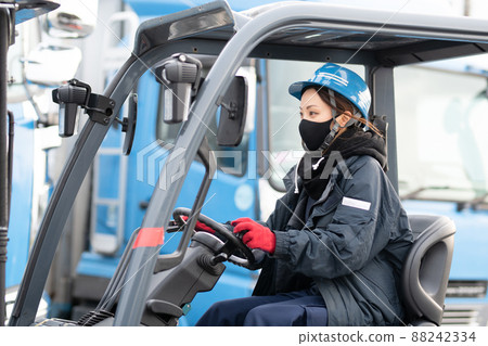 Woman maneuvering a forklift 88242334