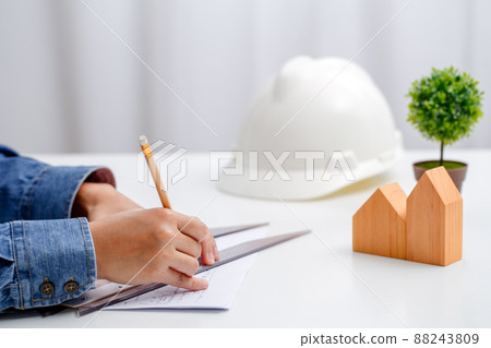 Architects or Engineer are using ruler tools to measure distance from floor plans to design houses. Architects or Engineer are using ruler tools to measure distance from floor plans to design houses. 88243809