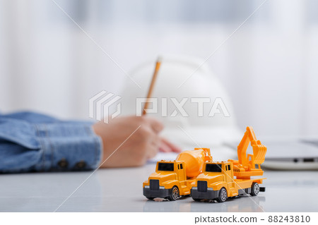 Concrete mixer truck and excavator on architect's desk, Engineering objects, Construction site. 88243810