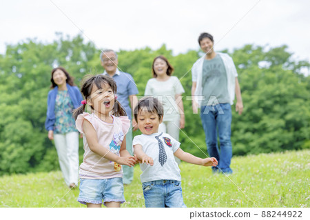 3rd generation family playing on the hills of the park 3rd generation family playing on the hills of the park 88244922