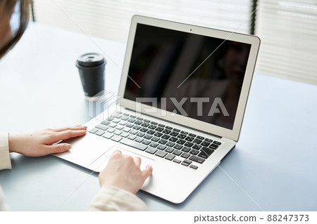 Asian woman operating a laptop 88247373