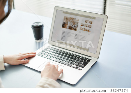 Asian women viewing real estate websites on a computer 88247374