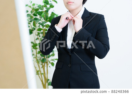 A young woman in a suit who checks her clothes with a full-length mirror in the morning. A young woman in a suit who checks her clothes with a full-length mirror in the morning. 88248366