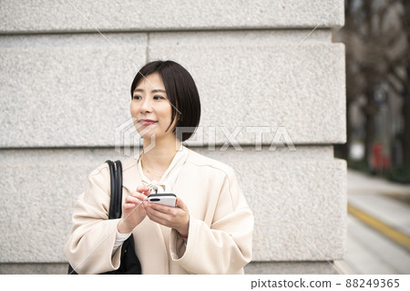 Woman operating a smartphone Woman operating a smartphone 88249365