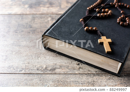Rosary catholic cross on holy bible isolated on white background Rosary catholic cross on holy bible isolated on white background 88249997