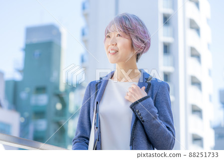 一名中年婦女站在建築物背景中拿著文件的肖像 88251733