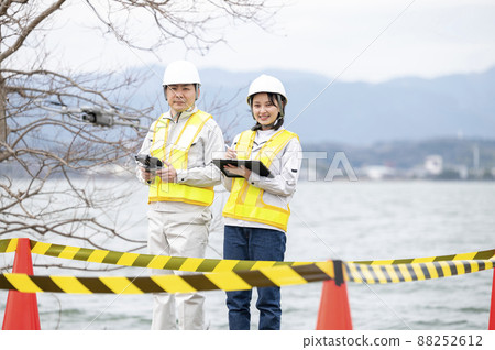 Worker operating a drone, taken in March 2022 in Shiga Prefecture 88252612