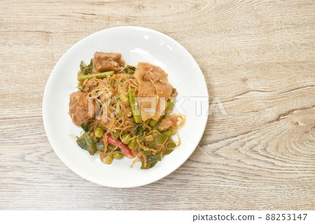 spicy stir fried glass noodles with pickled bamboo and mixed vegetable couple pork Thai northern style food called Pad Hor on plate 88253147