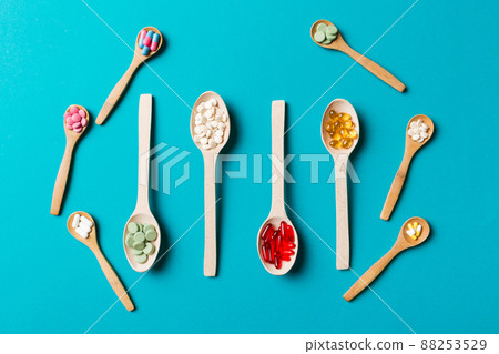 Top view Variety of vitamin and mineral pills in wooden spoon on Colored background. Top view of assorted pharmaceutical medicine pills. Dietary supplement healthcare product Top view Variety of vitamin and mineral pills in wooden spoon on Colored background. Top view of assorted pharmaceutical medicine pills. Dietary supplement healthcare product 88253529