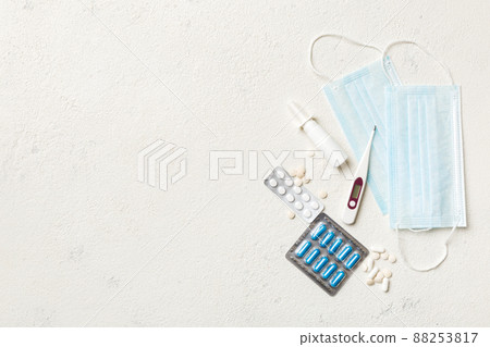 Protective face masks or surgical masks, medicine pills and thermometer on table background. Coronavirus disease. Corona virus concept. Space for text Protective face masks or surgical masks, medicine pills and thermometer on table background. Coronavirus disease. Corona virus concept. Space for text 88253817
