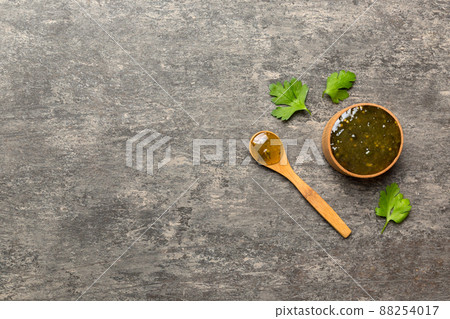 bowl of basil sauce in wooden bowl with spoon on wood background. Top view with copy space 88254017