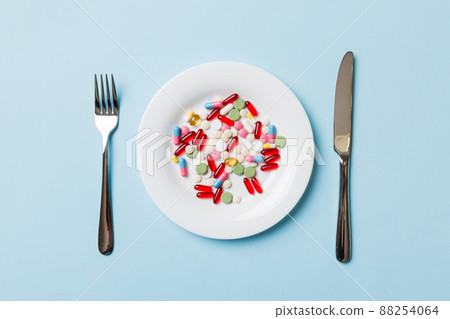 Many different weight loss pills and supplements as food on round plate. Pills served as a healthy meal. Drugs, pharmacy, medicine or medical healthycare concept 88254064