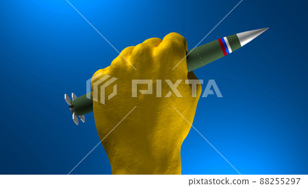 hand in colors of Ukrainian flag holding russila ballistic missle on blue background hand in colors of Ukrainian flag holding russila ballistic missle on blue background 88255297