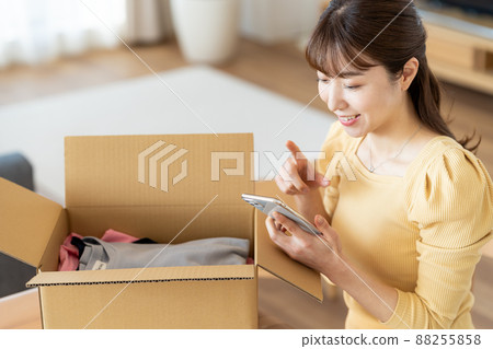 一個女人在客廳裡收拾紙板 88255858