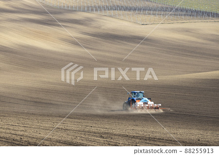 Tractor with seed drill in early spring landscape 88255913