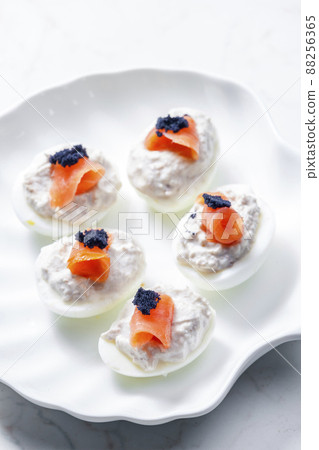 boiled eggs filled with tuna fish spread and smoked salmon and  black caviar on the top 88256365
