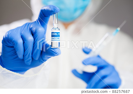 Medical laboratory scientist technician holding a syringe and COVID-19 coronavirus disease vaccine ampoule Medical laboratory scientist technician holding a syringe and COVID-19 coronavirus disease vaccine ampoule 88257687