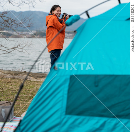 my hobby! A young woman taking a picture by the lake 88258201