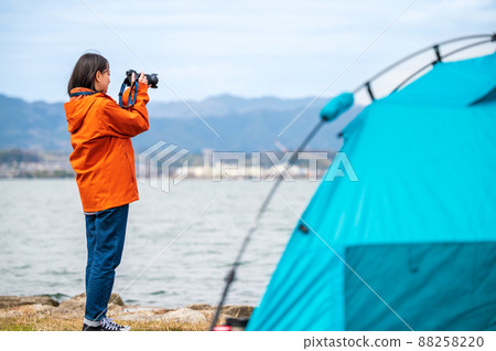 my hobby! A young woman taking a picture by the lake my hobby! A young woman taking a picture by the lake 88258220