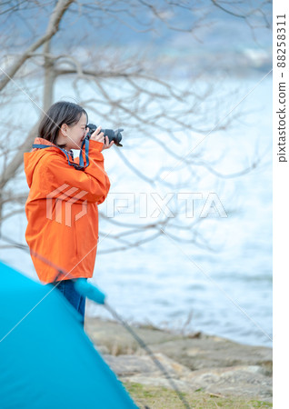 [High key correction] A young woman taking a picture by the lake 88258311