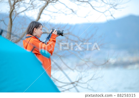 [High key correction] A young woman taking a picture by the lake 88258315