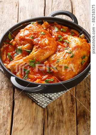 Chicken legs baked in onion tomato sauce close-up in a frying pan. vertical 88258375