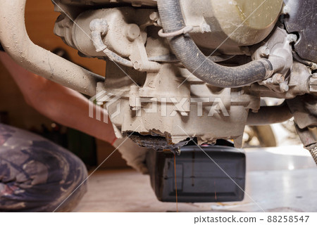 The process of draining oil from a motorcycle engine. Engine oil upgrade. The process of draining oil from a motorcycle engine. Engine oil upgrade. 88258547