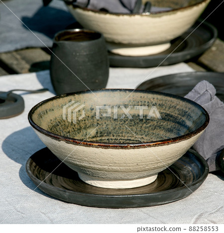 Rustic table setting outside in garden with empty craft ceramic tableware 88258553
