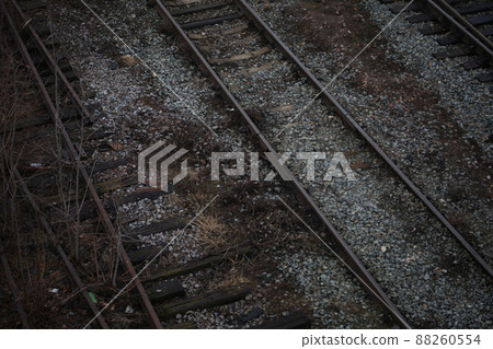 Abandoned railroad tracks. Steel rails overgrown with grass 88260554