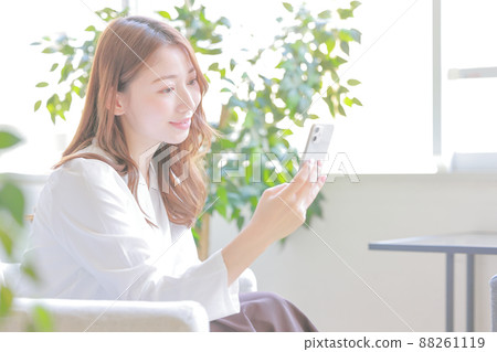 A woman who smiles at her smartphone 2 A woman who smiles at her smartphone 2 88261119