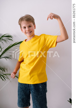 Happy teenager pointing at his t-shirt. Yellow t-shirt mockup 88261775