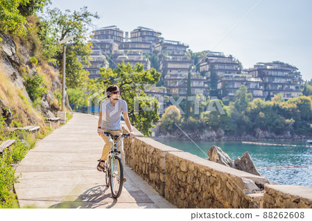 Man tourist on a bicycle explores Budva in Montenegro. Cycling in Montenegro concept 88262608