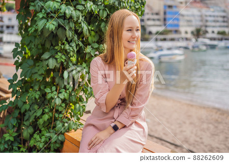 Close up of pretty tourist girl eating traditional gelato italian ice cream in a European town 88262609