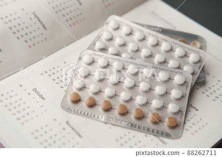 birth control pills , calendar and notepad on table  88262711