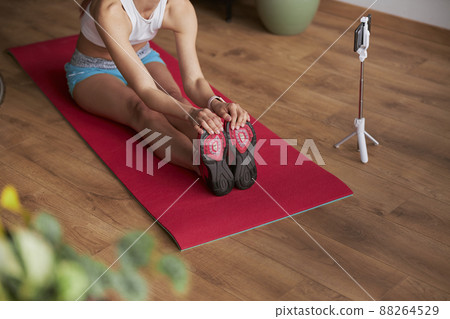 Flexible lady shoots nw video doing forward bend while sitting on floor 88264529