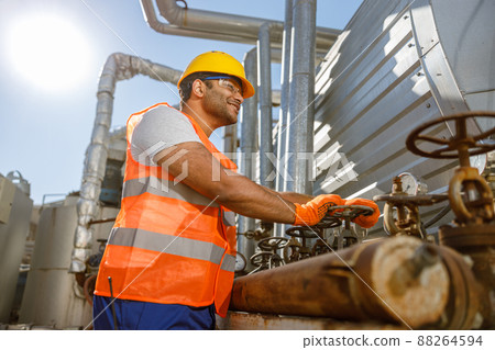 Skillful multiethnic engineer working at heavy industry plant Skillful multiethnic engineer working at heavy industry plant 88264594