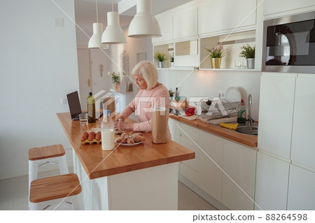 Senior woman is preparing meal in kitchen 88264598