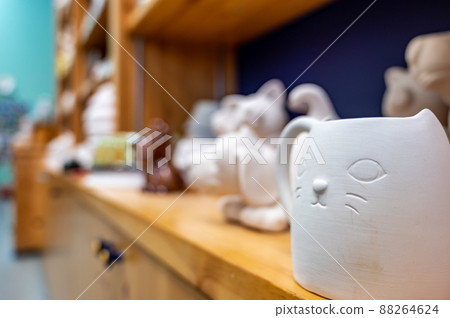 Row of blank unfinished ceramic figures on a studio shelf in a DIY store for painting. Row of blank unfinished ceramic figures on a studio shelf in a DIY store for painting. 88264624