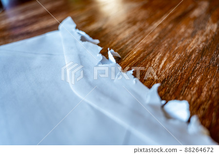 Selective focus on jagged edges of a ripped open mail envelope  88264672