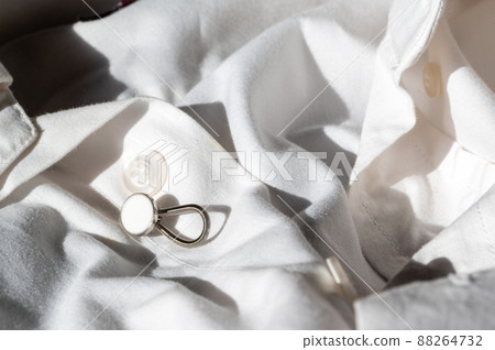 button extender shown on a white dress shirt to increase size 88264732