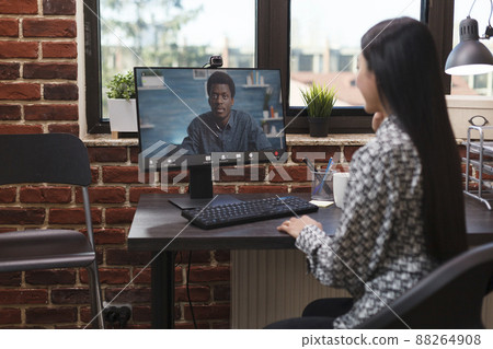 Company office worker in online digital videocall with accounting manager talking about business financial success. Asian team leader in internet remote conference with agency colleague. Company office worker in online digital videocall with accounting manager talking about business financial success. Asian team leader in internet remote conference with agency colleague. 88264908