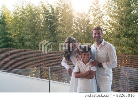 Happy family resting on the balcony of a luxury house surrounded by forest nature. Selective focus  88265016